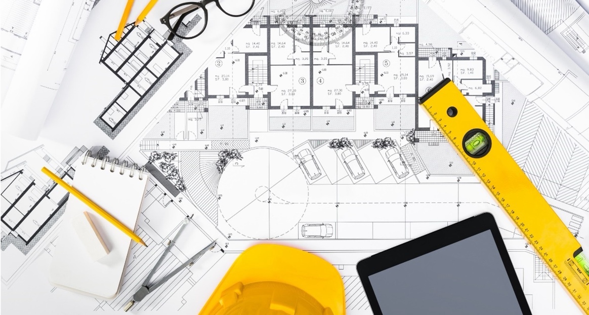 Architectural blueprints, hard hat and drafting tools on a desk — Singapore Design for Safety specialist